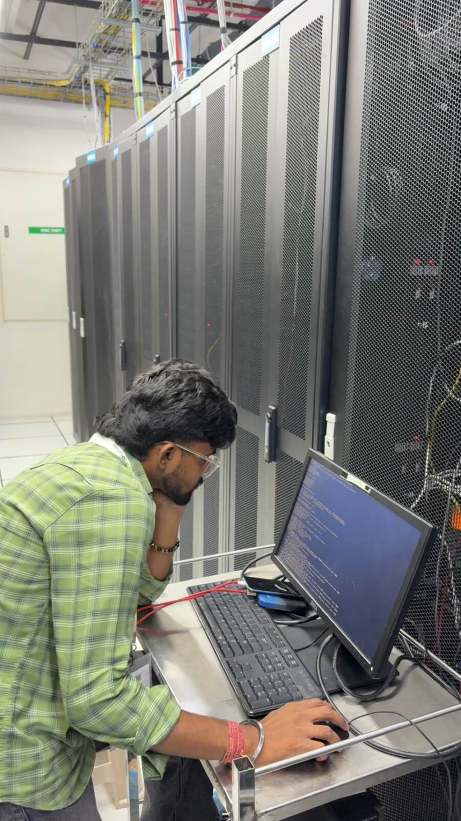 eWebGuru engineer running an OS install from a console cart beside the server rack